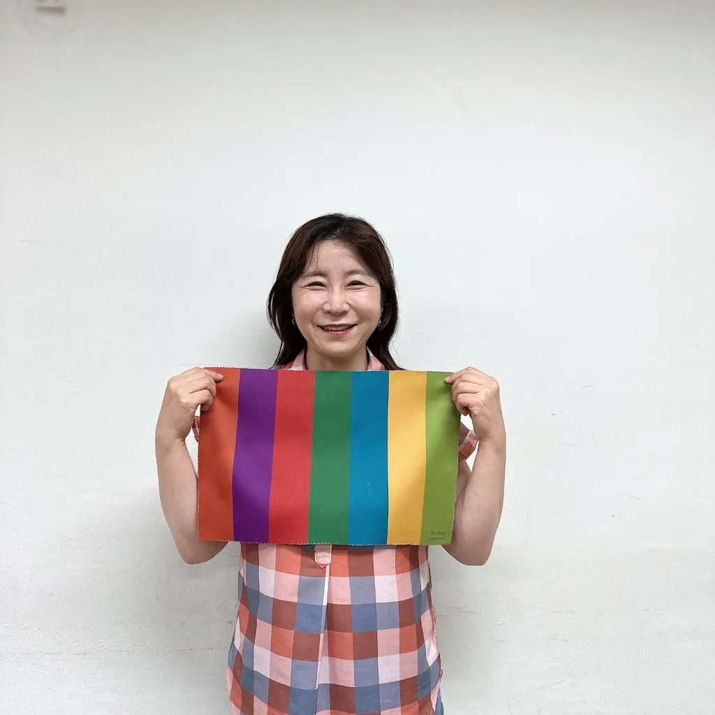 밝은 실내에서 무지개색 컬러 드레이프 천을 직접 들어 보이는 진단 도구 소개 장면